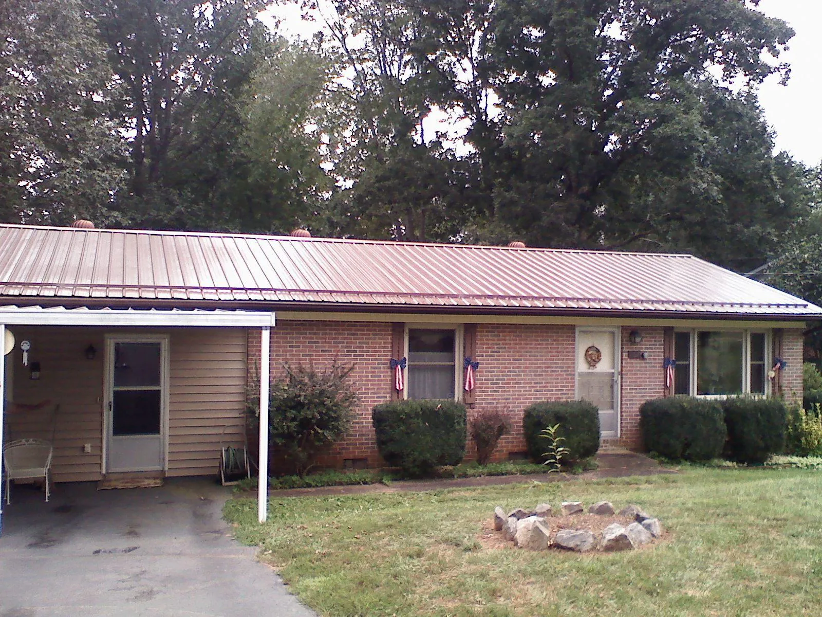 Bronze metal roof and carport on a brick ranch home — Roof Repair work by our crew in Uniontown